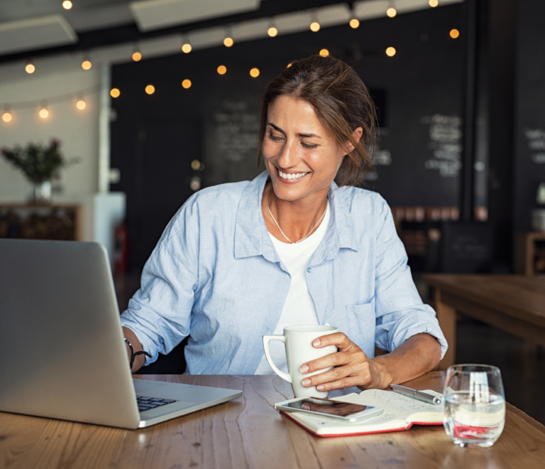 woman holding a cup of coffee while working